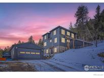 Inviting exterior of a two-story home featuring a matching garage and beautiful sunset skies at 11932 Coal Creek Heights Dr, Golden, CO 80403