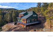 Stunning mountain home featuring a multi-tiered deck and beautiful forest surroundings at 1406 Pika Rd, Boulder, CO 80302