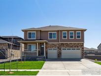 Attractive two-story home featuring a brick and siding facade, covered porch, and three-car garage at 1860 Chaffee Crest Dr, Berthoud, CO 80513