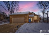 Charming home featuring a brick facade, a two-car garage, and a snow-covered front yard at 3660 Larkwood Ct, Boulder, CO 80304