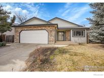 Charming single-Gathering home featuring stone accents, a two-car garage, and a well-maintained front yard at 465 Orchard Dr, Louisville, CO 80027