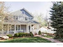 Charming two-story home featuring a welcoming front porch, manicured lawn, and beautiful landscaping at 521 Hawthorn Ave, Boulder, CO 80304