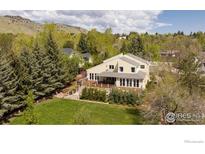 Stunning two-story home boasts a large deck, manicured lawn and mature trees offering privacy and shade at 700 Linden Ave, Boulder, CO 80304
