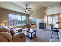 Inviting living room with a cozy fireplace and a large window view at 1379 Charles Dr # E5, Longmont, CO 80503