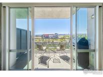 A balcony view with furniture overlooking the city and sports stadium at 1401 Wewatta St # 714, Denver, CO 80202