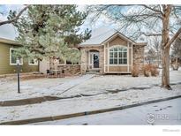 Charming home featuring a stone facade, manicured front lawn, and inviting entrance at 1629 Metropolitan Dr, Longmont, CO 80504