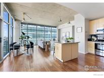 Bright living room with hardwood floors, modern furnishings, and floor-to-ceiling windows offering cityscape views at 1700 Bassett St # 1303, Denver, CO 80202