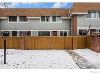 Charming townhome showcasing inviting curb appeal with a wooden fence and brick accents at 2016 W 101St Ave, Thornton, CO 80260