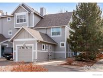 Charming townhome with a two-car garage and attractive curb appeal on a sunny day at 2256 Watersong Cir, Longmont, CO 80504