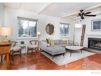 Bright living room featuring hardwood floors, a fireplace, and a comfortable gray sectional sofa at 3630 Iris Ave # D, Boulder, CO 80301