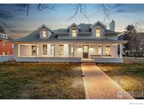 Inviting exterior of a two-story home showcasing a charming brick walkway, large porch, and well-manicured lawn at 502 Highland Ave, Boulder, CO 80302