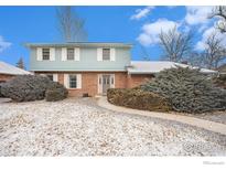 Two-story home featuring brick facade and light blue siding under a sunny sky and partial snow cover at 7169 Mount Meeker Rd, Longmont, CO 80503