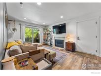 Cozy living room featuring a fireplace, sliding door to balcony and comfortable seating at 8050 Niwot Rd # 58, Niwot, CO 80503