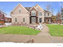 Beautiful two-story stucco home featuring a stone facade and a well-manicured front yard at 1321 Onyx Cir, Longmont, CO 80504