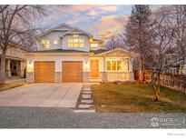 Charming two-story home boasts a manicured lawn, stone accents, and a two-car garage at 1575 Kalmia Ave, Boulder, CO 80304