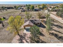 Aerial view of a home and property with attached garage and mature trees at 4025 Arleigh Dr, Berthoud, CO 80513