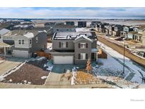 Two-story home featuring gray siding, solar panels, a two-car garage, and a manicured front lawn at 6233 Easton Ave, Frederick, CO 80504