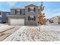 Charming two-story home featuring gray siding, brown shutters, and an attached two-car garage at 6233 Easton Ave, Frederick, CO 80504