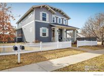 Charming two-story home with blue siding, white trim, and a classic white picket fence at 722 Hutchinson St, Louisville, CO 80027