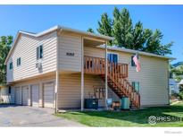 Charming two-story home featuring a wooden staircase, covered porch, and a well-maintained front lawn at 1057 W 112Th Ave # D, Denver, CO 80234