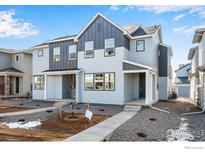 Modern townhouse exterior with gray siding, dark accents, and manicured front yard at 1419 Great Western Dr, Longmont, CO 80501