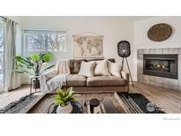 Bright living room with a decorative fireplace, neutral-toned sofa, and a large world map at 1601 Great Western Dr # 3, Longmont, CO 80501