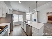 Bright, open floor plan showcases the kitchen island connecting to a great room with cozy fireplace at 265 High Point Dr # 201, Longmont, CO 80504