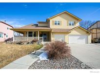 Charming two-story yellow home with a covered front porch and a two car garage at 288 Dover Ct, Broomfield, CO 80020