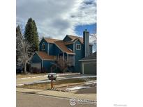 Charming two-story blue home with a well-maintained front yard and attached garages at 4491 Wellington Rd, Boulder, CO 80301