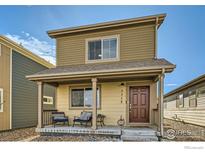 Charming home featuring a covered front porch with cozy seating to enjoy neighborhood views at 1117 Hummingbird Cir, Longmont, CO 80501