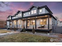 Stunning gray two-story home featuring a charming front porch with dark railings and a meticulously maintained lawn at 2122 Goss Cir, Boulder, CO 80302