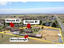 Aerial view of horse property including two houses, barn/garage and large fenced riding area at 3380 County Road 38, Mead, CO 80542