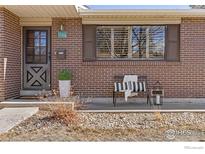 Charming front porch featuring a bench, stylish decor, and a well-maintained brick facade at 1104 Sherri Mar Ct, Longmont, CO 80501