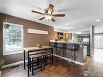 Cozy dining area features stylish table set and breakfast bar seating, seamlessly connecting to the kitchen at 1818 S Quebec Way # 3-1, Denver, CO 80231