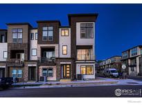 Modern townhome exterior showcasing a stylish design with mixed materials and private balconies at dusk at 375 Marshall Rd, Superior, CO 80027