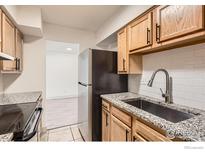 An updated kitchen features granite countertops, stainless steel sink and appliances at 4639 S Lowell Blvd, Denver, CO 80236