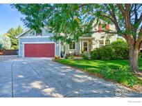 Charming two-story home featuring a well-maintained lawn and a spacious driveway leading to a red garage door at 510 Folklore Ave, Longmont, CO 80504