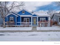 Charming blue home with a welcoming front porch and snow-covered yard at 5126 Mt Buchanan Ave, Frederick, CO 80504