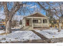 Charming single-Gathering home featuring a covered porch and manicured front yard with mature trees at 535 Dewey Ave, Boulder, CO 80304