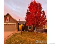 Charming single-Gathering home with a well-maintained yard and a beautiful red maple tree in full autumn color at 6242 Valley Vista Ave, Firestone, CO 80504