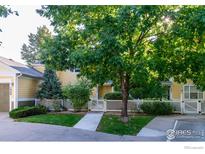 Charming two-story home featuring a well-manicured lawn, inviting walkway, and a white picket fence at 635 Gooseberry Dr # 1908, Longmont, CO 80503