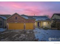 Charming home showcasing a brick facade, two-car garage, solar panels, and a welcoming front porch at 6596 Silverleaf Ave, Firestone, CO 80504