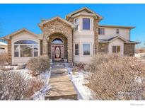 Beautiful two-story home with stone accents and a charming arched entryway at 6943 Saddleback Ave, Firestone, CO 80504