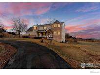 Charming two-story home with brick and siding exterior and circular drive at 7208 Secrest Ct, Arvada, CO 80007