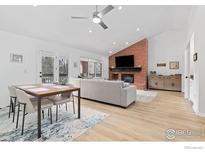 Bright living room featuring a brick fireplace, modern furniture, and beautiful flooring at 7243 Siena Way, Boulder, CO 80301