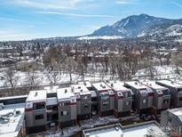 Stunning aerial view of townhomes with snow-capped mountains in the background under a clear blue sky at 856 Walnut St # A, Boulder, CO 80302