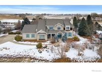 Charming two-story home featuring stone accents, light shutters, mature trees, and a professionally landscaped front yard at 8916 Prairie Knoll Dr, Longmont, CO 80503