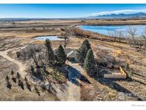 Gorgeous aerial view of estate property with mature landscaping near large pond and lake in a picturesque setting at 10075 N 75Th St, Longmont, CO 80503