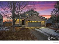 Charming two-story home with brick accents, a two-car garage, and a well-maintained front yard at 1495 Hickory Dr, Erie, CO 80516