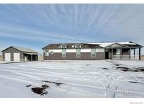 Charming single-story home with gray and white siding, and covered front porch at 17916 County Road 38, Platteville, CO 80651